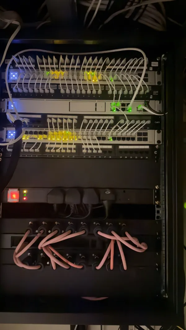 Finished wall cabinet for the Control4 rescue in Cork, with two network switches, 24 port Cat6 patch panels, short white patch leads, a surge protected power strip and two rows of Speakon speaker panels