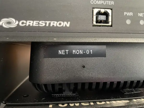 Printed label reading NET MON-01 on a device in the rack, matching the system documentation