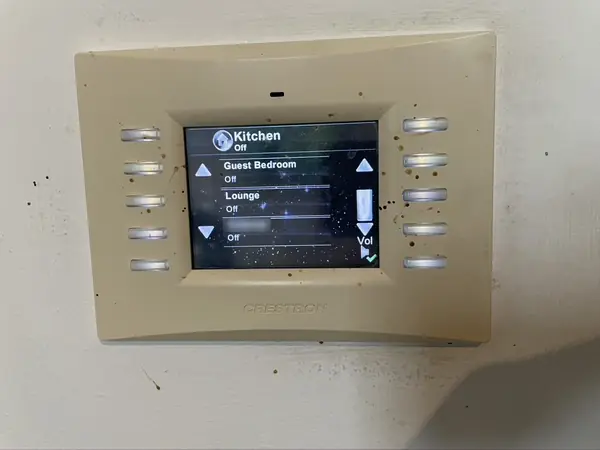 Older Crestron colour touch panel listing rooms such as Kitchen, Guest Bedroom and Lounge