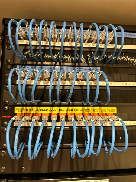 Patch panels labelled room by room, from the kitchen island and bedrooms to the alarm