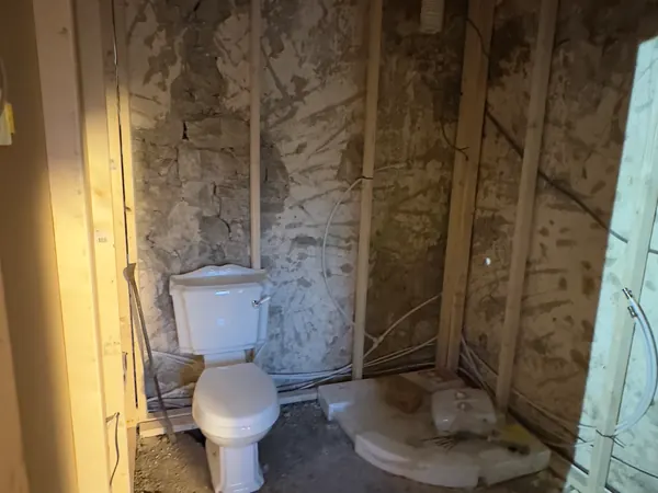 The bathroom at Ivy Cottage in Roscommon framed out in timber against the stone wall, with the toilet pan waiting for the first plumbing
