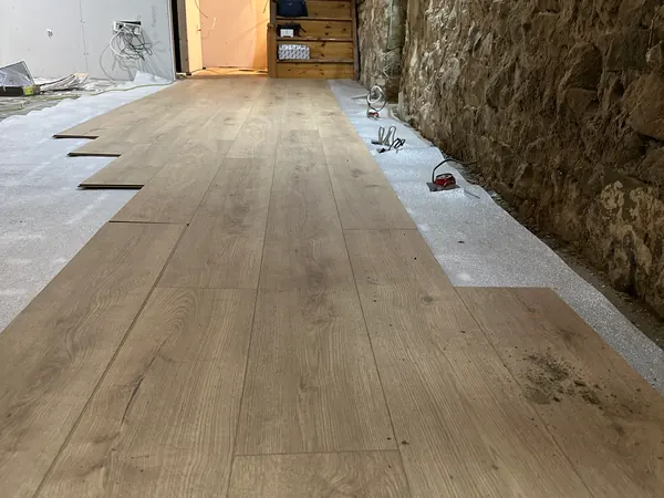 The new oak floor going down at Ivy Cottage in Roscommon along the exposed stone wall towards the stairs