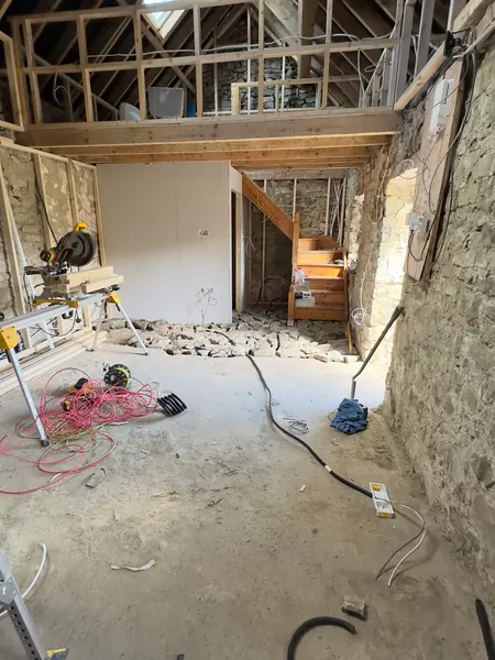 The new staircase with first fix cables run along the stone walls and across the floor