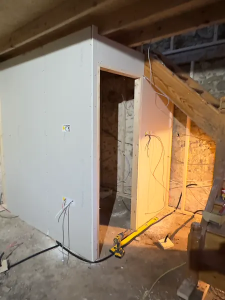 Stud walls, insulation and the staircase during first fix, with cables run before the plasterboard