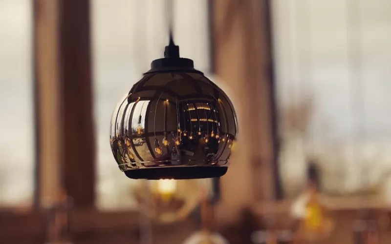Close view of a dark glass pendant lamp with a filament bulb