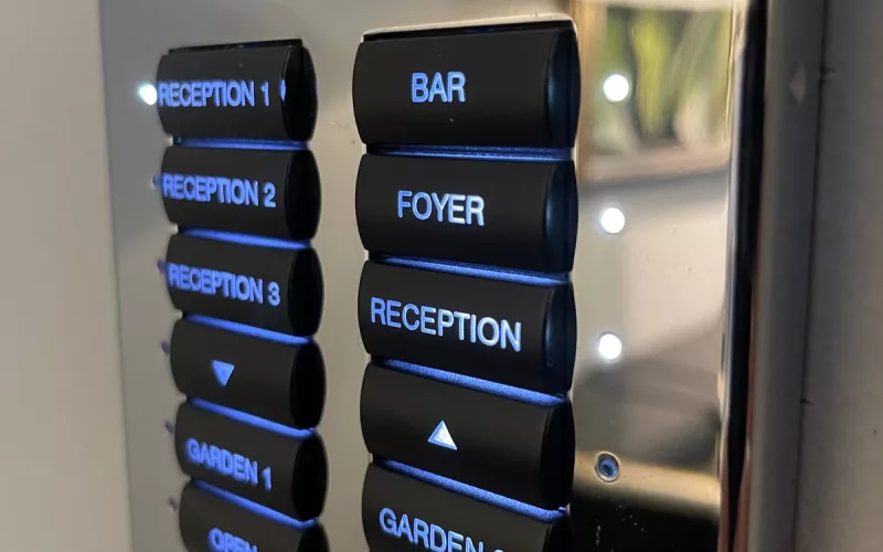 Lighting keypads done properly: a chrome plate whose engraved labels for the reception rooms, the bar, the foyer and the garden glow blue
