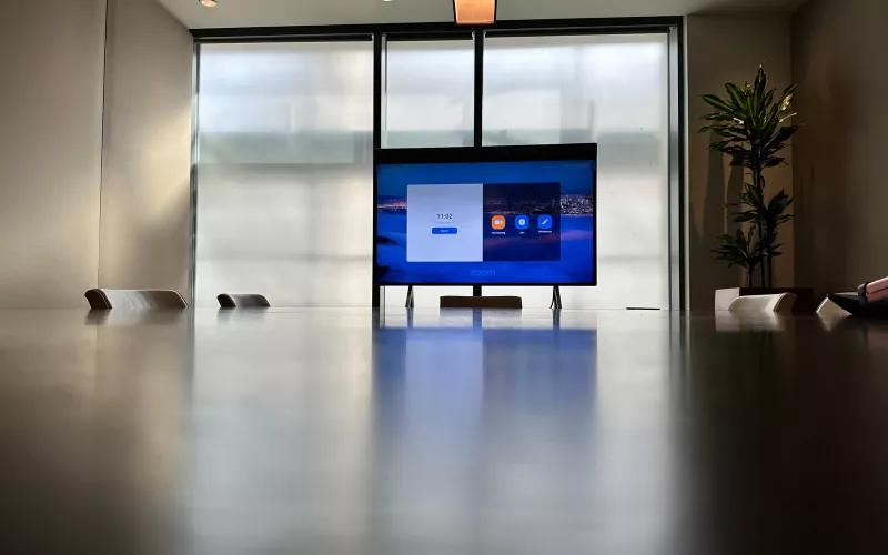 Neat Board installation in a Dublin boardroom, with the board on its stand at the far end of a long dark table and the windows behind it