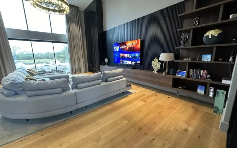 Double height living room with an integrated TV and audio