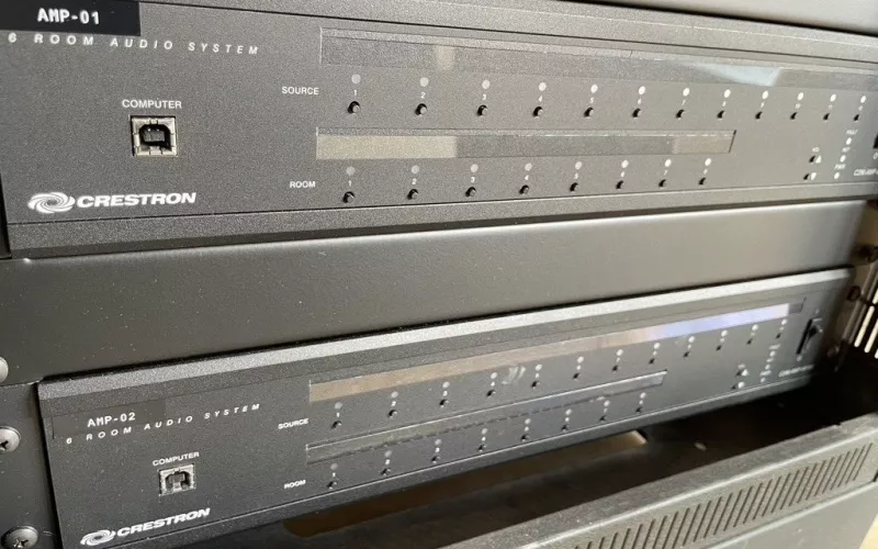 Two Crestron six room audio systems in an equipment rack, labelled AMP-01 and AMP-02