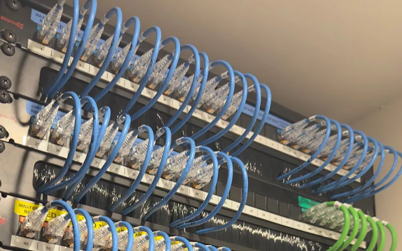 Home network rack with colour coded patch leads, every port labelled by room