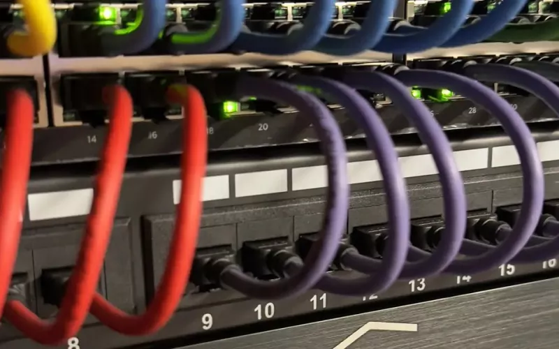Close up of a network patch panel with colour coded cables