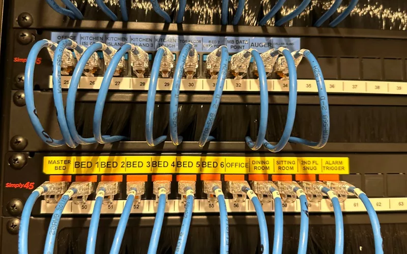 Patch panels labelled room by room, from the kitchen island and bedrooms to the alarm