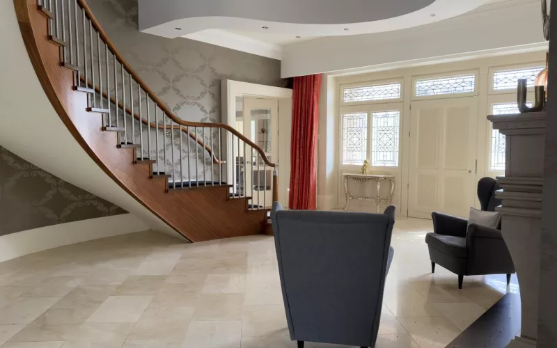 Control4 network problems in Galway: the hall of the house, with a curved timber staircase, a marble floor and two armchairs