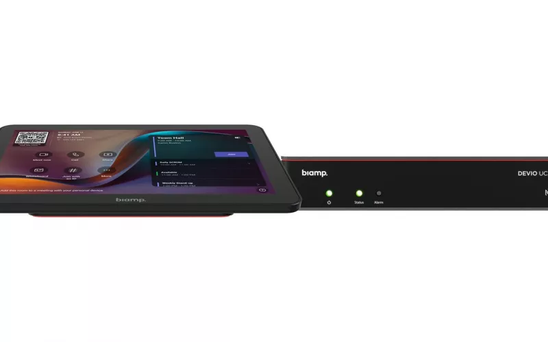 Front view of the black Biamp Devio UCX 1000 compute with its green status lights, beside an Apprimo Touch 10 panel showing the Teams Rooms home screen