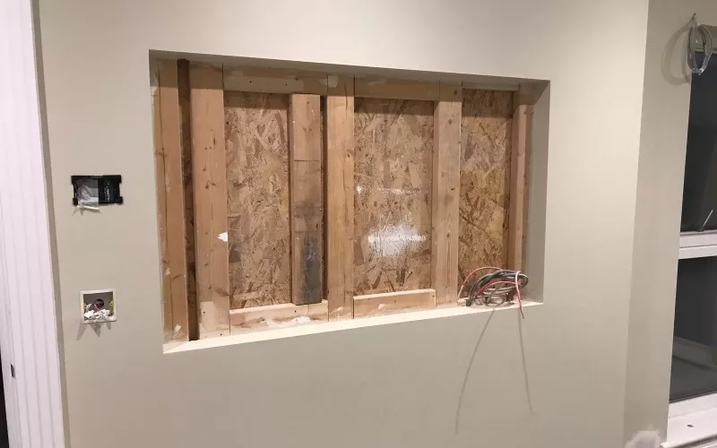 Recess framed into a living room wall at first fix with TV wiring and a back box left ready for the screen