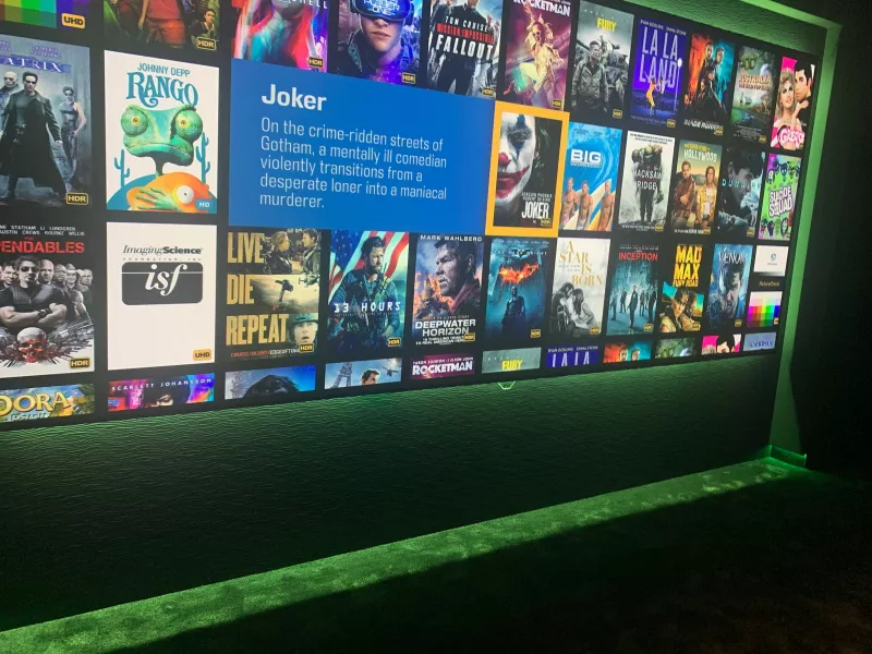 A film library on the cinema screen, ready to choose from, above a strip of green light at floor level