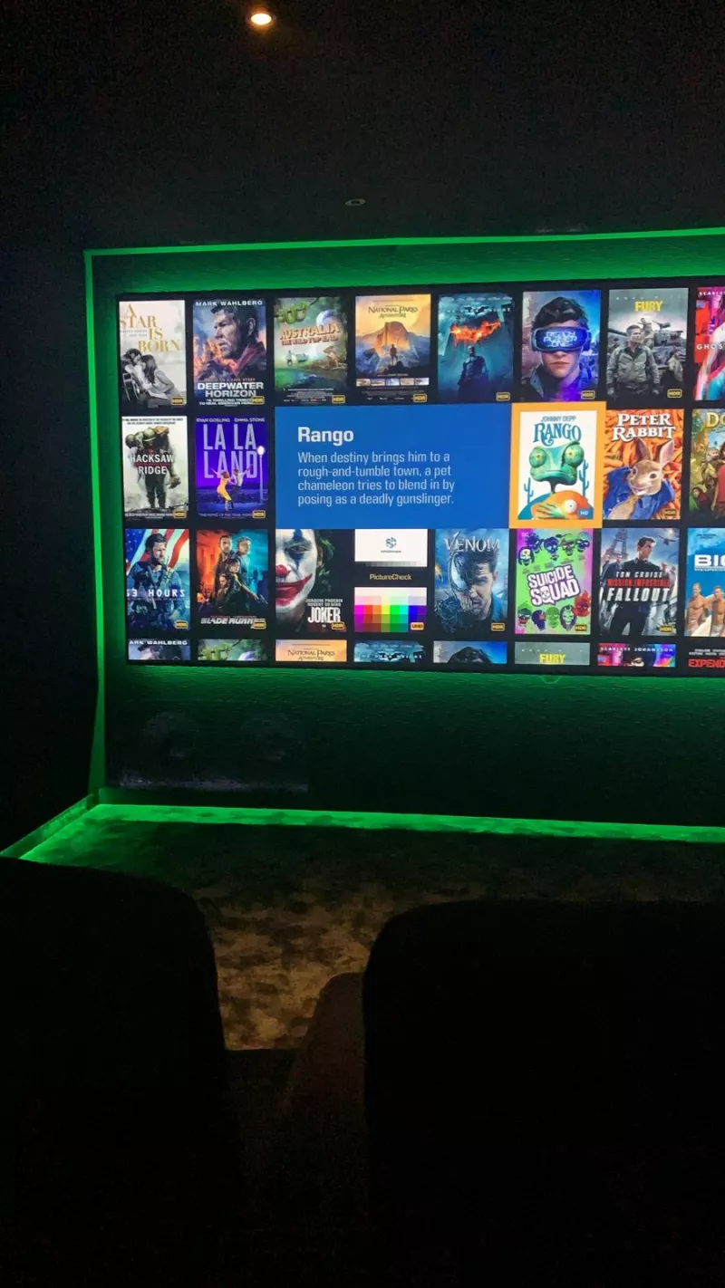The cinema screen inside a green glowing frame, with a second line of green light where the wall meets the floor