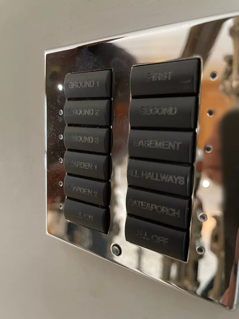 A second chrome keypad organised by floor, with buttons for each storey, the hallways, the gate and porch, and all on and all off