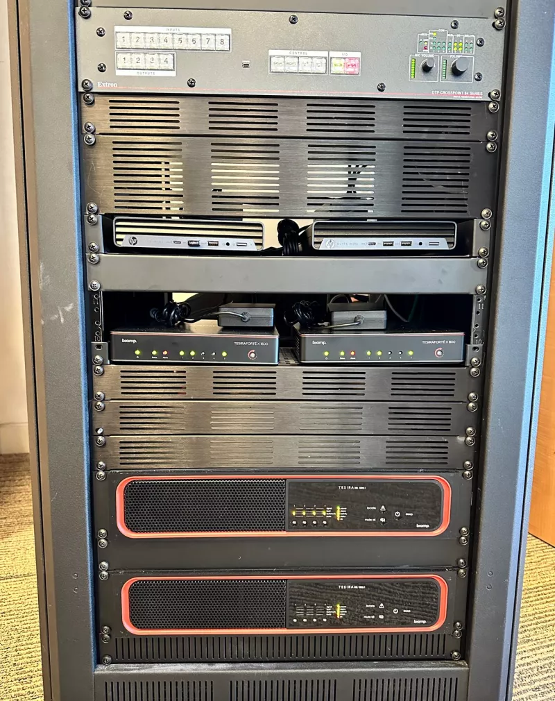 The lower half of the rack: an Extron DTP CrossPoint 84 switcher, two HP Elite Mini computers, Biamp TesiraFORTÉ X 1600 and X 800 processors and two Biamp TesiraXEL 1200.1 amplifiers