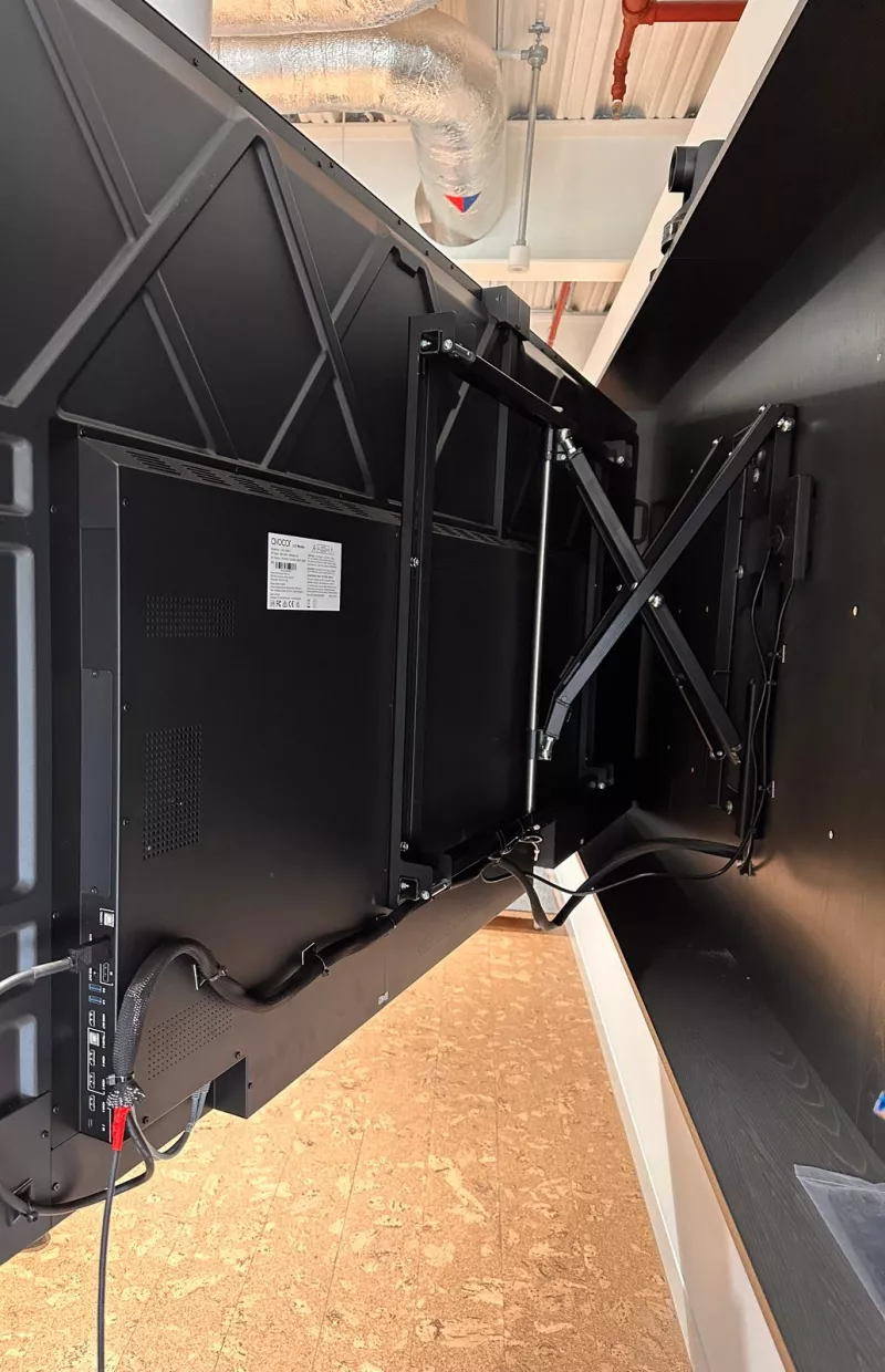 The Avocor display swung out from the wall, showing its cables gathered in braided sleeving and clipped to the frame