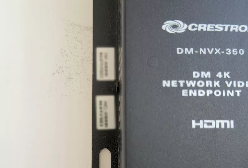 The model label of a Crestron DM-NVX-350, the network video box that feeds the TV
