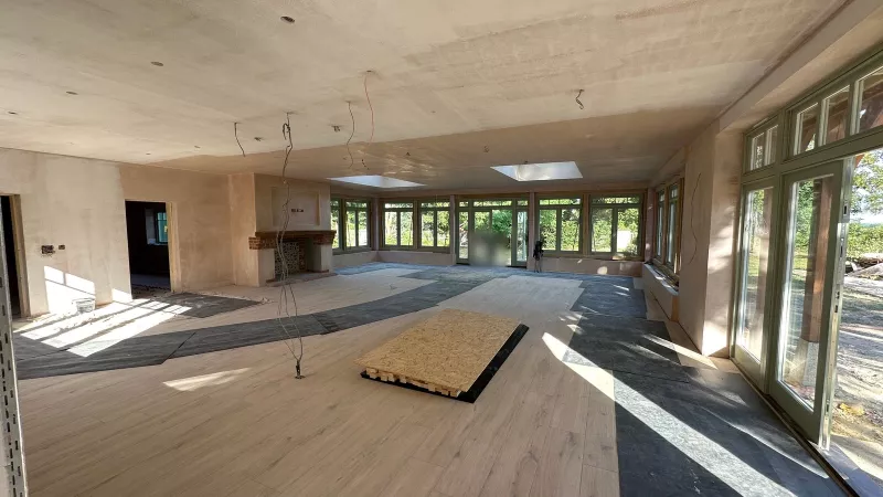 First fix in July: boarded ceilings, protected floors and cables hanging down, with the fireplace already built at the far end
