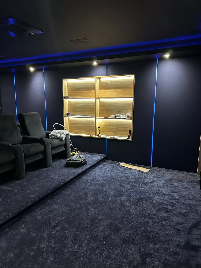 LED lit shelf unit set into the fabric wall beside the first cinema seats