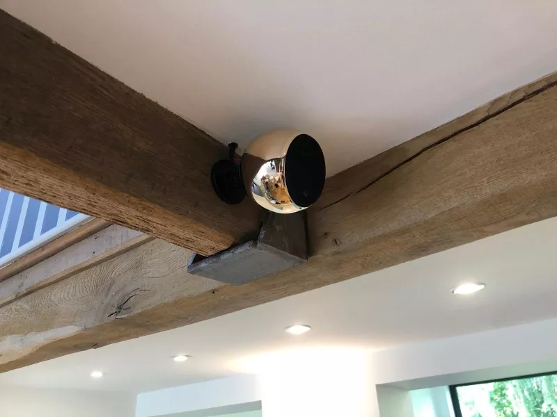 Spherical speaker mounted where the oak ceiling beams meet
