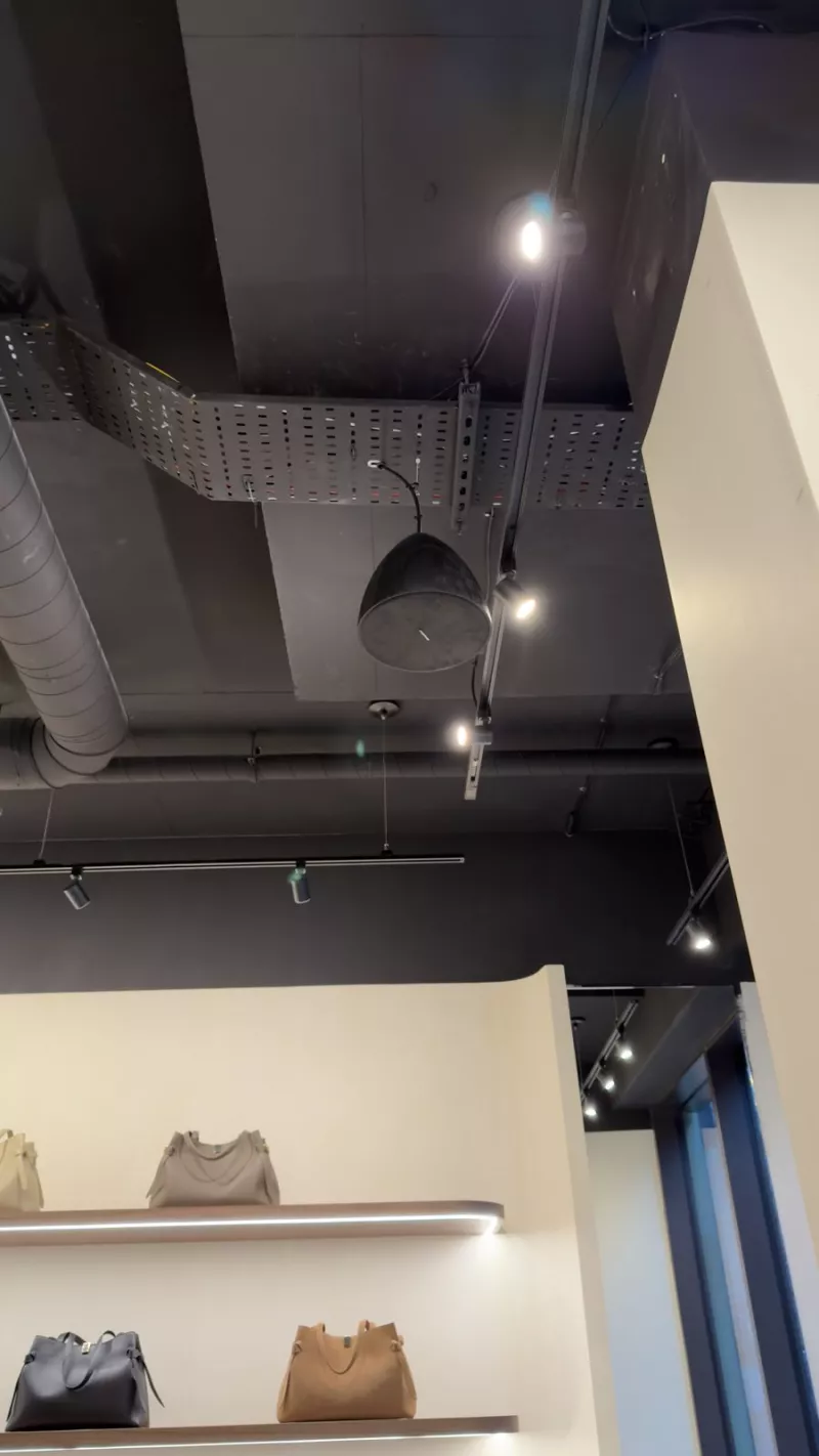 Exposed ceiling with speakers, track lighting and containment