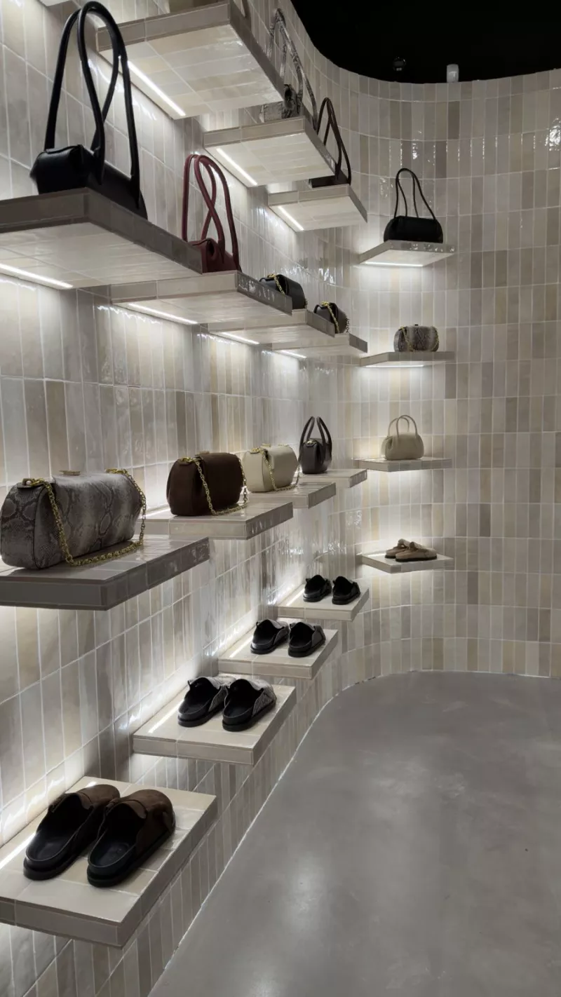 Curved display wall with individually lit shelves