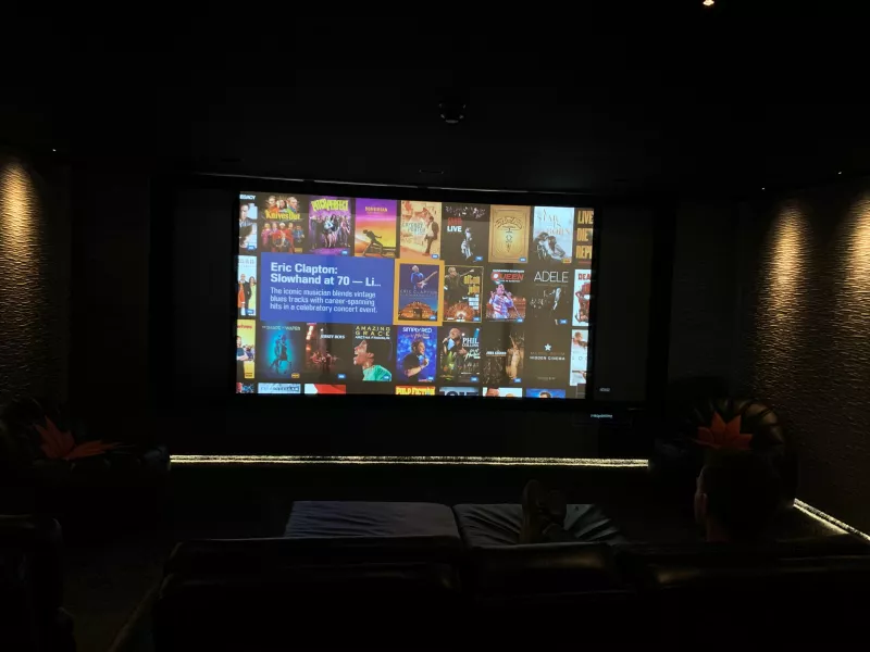 A film menu glowing on the big screen of a dark cinema room
