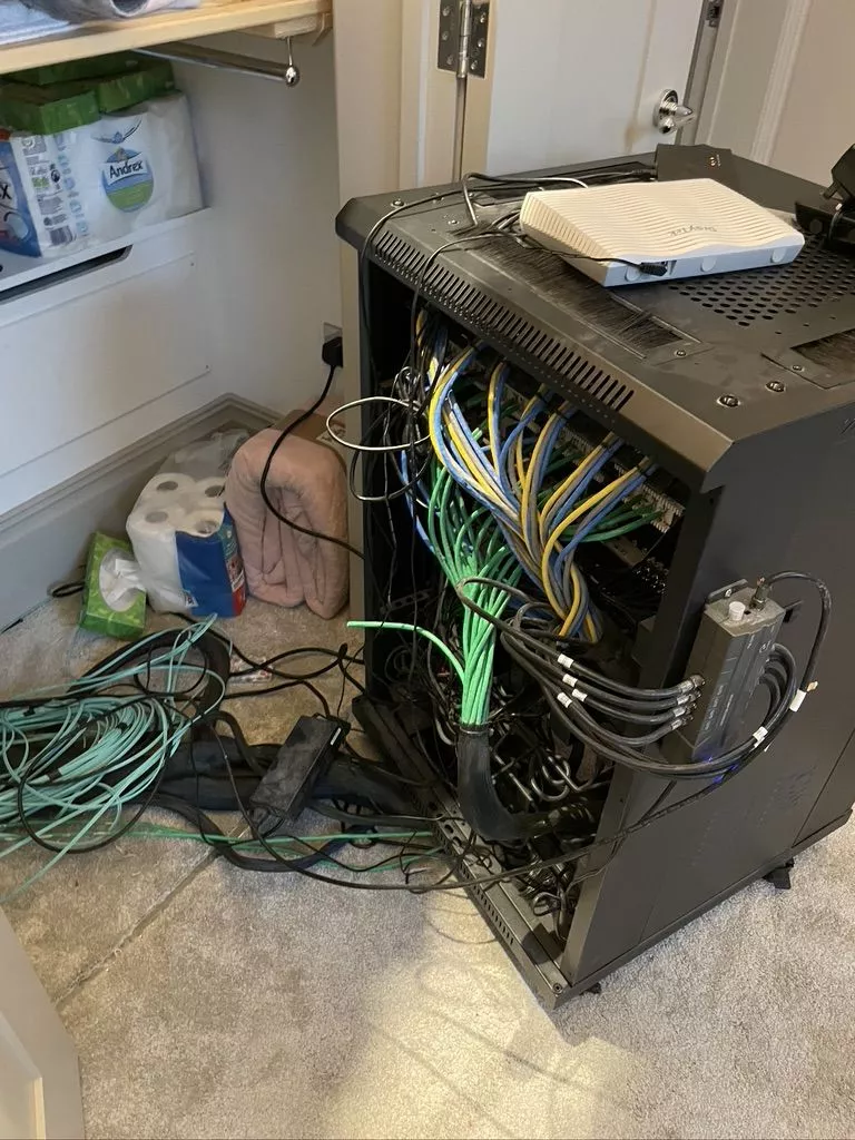 Tangled cabling behind the old cabinet