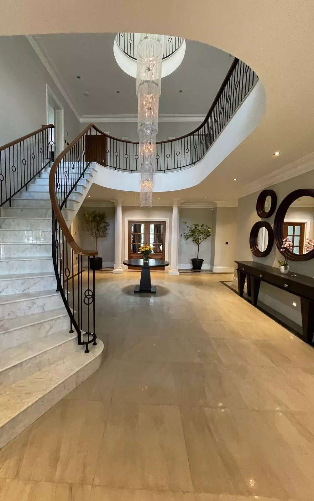Marble stair hall with round mirrors and a crystal chandelier, a large entrance a KNX installer in Galway lights by scene