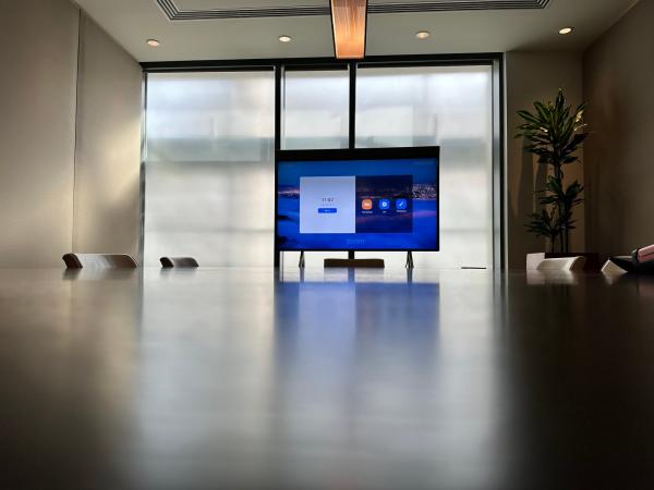 Neat Board installation in a Dublin boardroom, with the board on its stand at the far end of a long dark table and the windows behind it