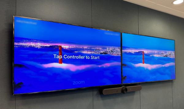 Zoom Rooms installation in Dublin: two wall displays side by side showing the Zoom logo, the left one with the message Tap Controller to Start, and a video bar below