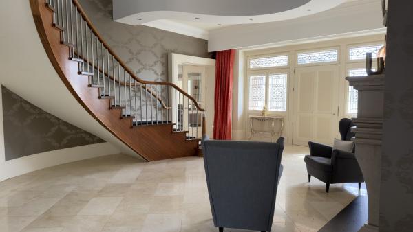 Control4 network problems in Galway: the hall of the house, with a curved timber staircase, a marble floor and two armchairs