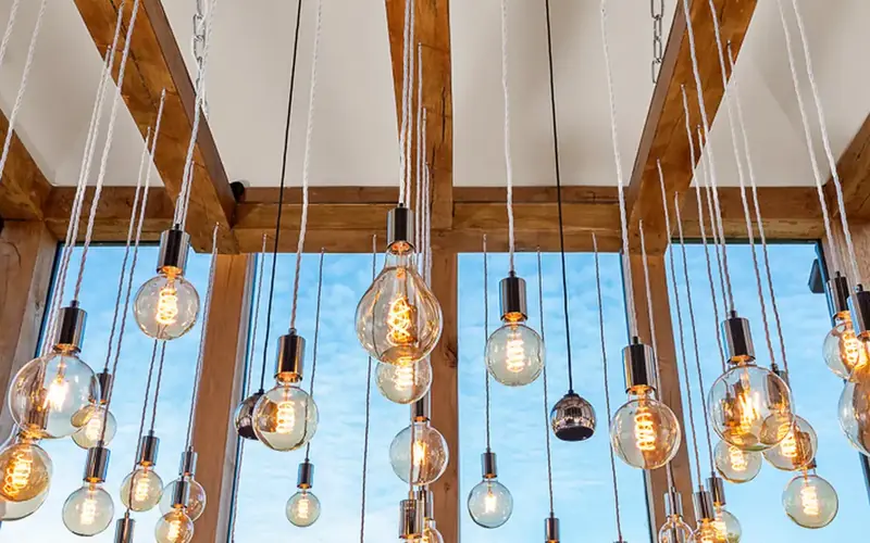Glass pendant bulbs on long cords below exposed timber beams