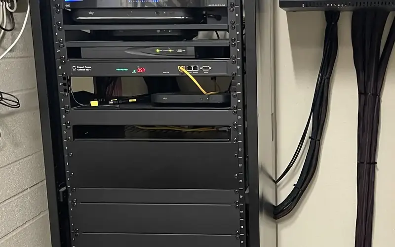 Neat AV rack with dressed black cabling running to the wall