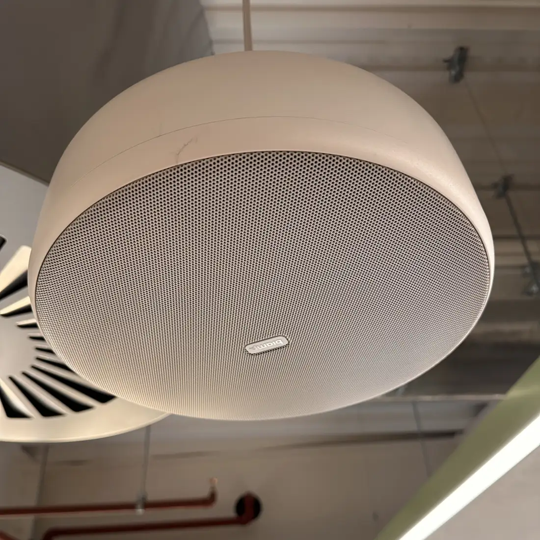 Meeting room ceiling with a round microphone and speaker unit