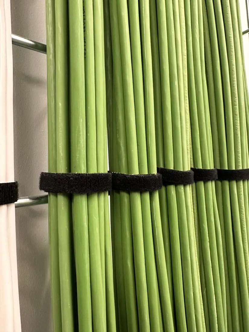 Bundles of green data cables tied in neat runs