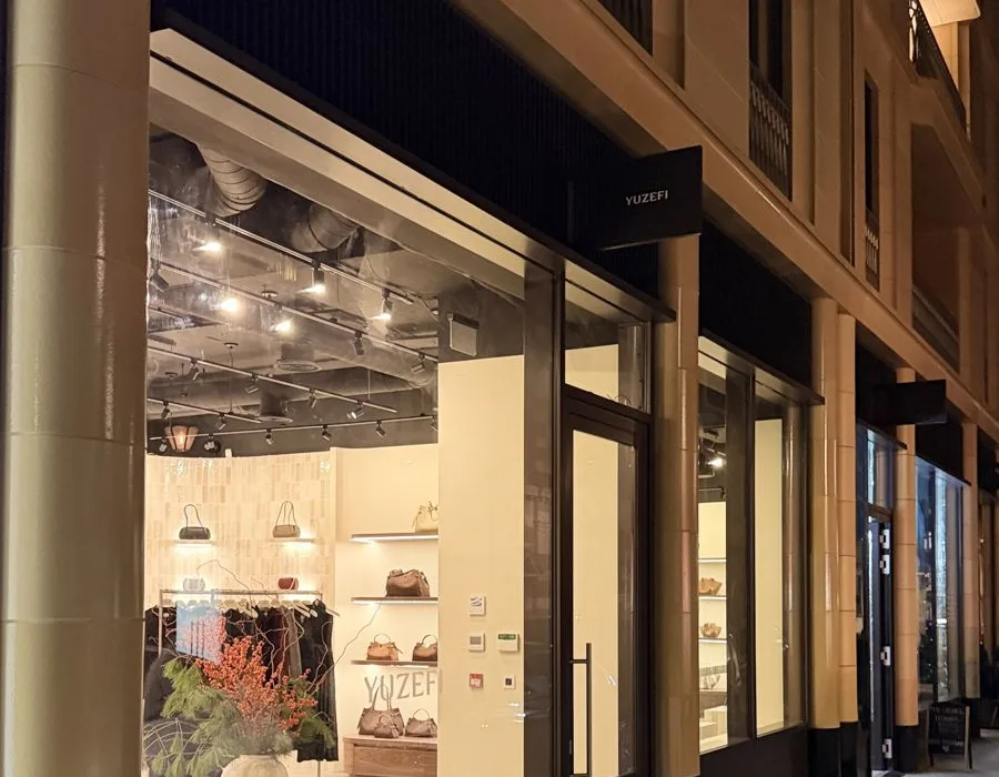Handbag boutique shopfront lit up at night