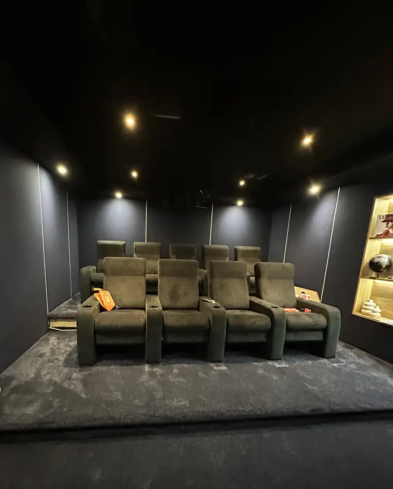 Private cinema room seen from the screen, with rows of recliners
